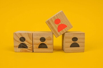 Red Wooden Cube With Person Icon Stand Out From The Crowd Over Yellow Background