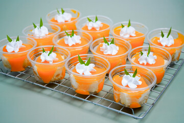 Orange ball cake placed on a grid on a green background.