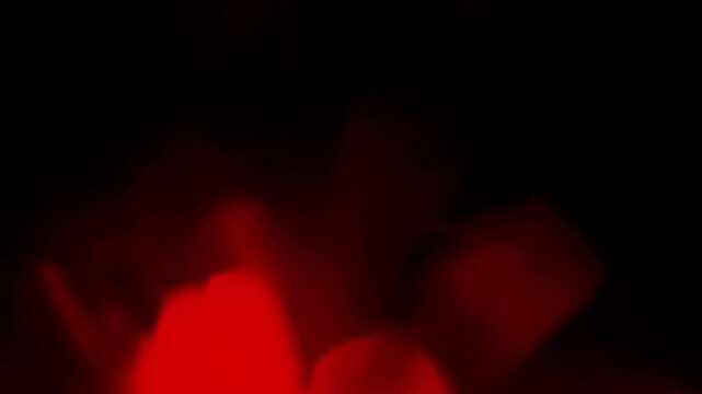 Soft, out-of-focus red bokeh lights drift and float in a seamless loop. Abstract background or overlay for creating a warm, romantic, or festive mood. Isolated on black background