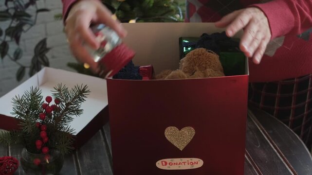 Christmas holiday donations for kids. Female volunteer collects toys in donation box. 