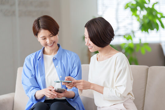 スマホを使う女性たち - Powered by Adobe