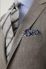 Close-up of a stylish suit with a patterned tie and pocket square.