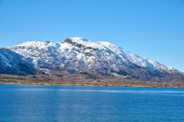 Obraz premium Ocean, mountain and landscape with blue sky in nature, outdoor and mockup space for travel. Holiday, vacation and winter environment with sea, snow and water for tourism in countryside in Norway