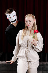 A loving mime expresses his feelings to a beautiful woman on a theater stage. Close-up.