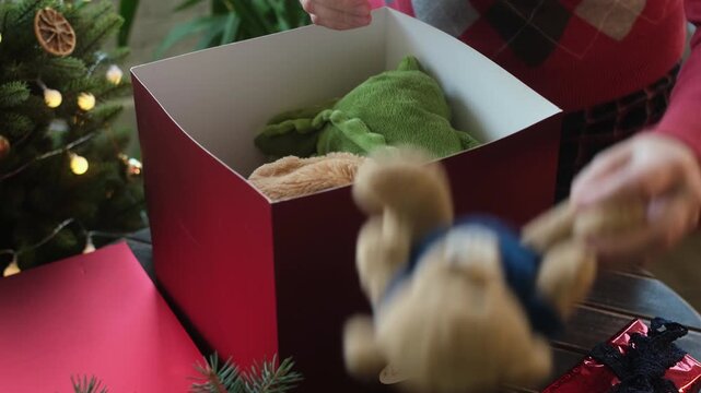 Charity. Christmas donation for children. Woman collecting toys and presents in donation box 