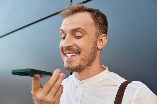 Young university teacher smiling while speaking into smartphone outdoors at sunset - Powered by Adobe