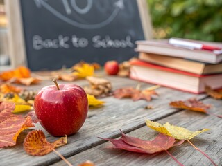 Apple and autumn leaves on a wooden table