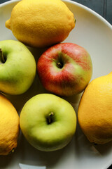 Colorful apples with lemons on white