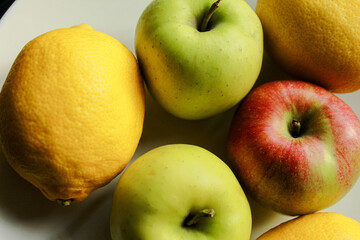Assorted apples and lemons on plate