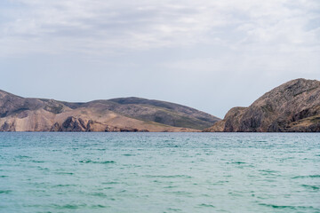 KRK Island, Baška, Croatia - April 18, 2025: View of the mountains and the village of Baška. Panorama of beautiful mountains and the sea