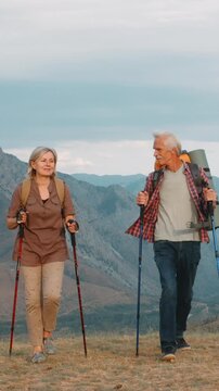 Vertical slow motion senior hikers mountain trail symbol strength resilience longevity freedom healthy lifestyle wellness outdoor activity active aging adventure motivation inspiration