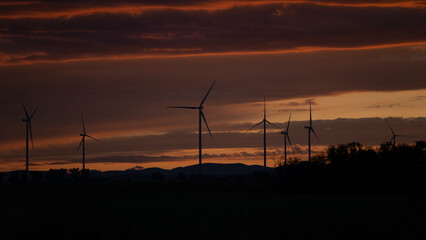 Wind turbines silhouette at sunset sky