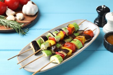 Vegetarian barbecue. Tasty grilled vegetables served on light blue wooden table, closeup