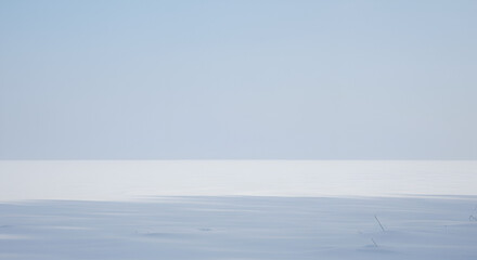 Serene winter landscape featuring a vast expanse of snow under a clear sky