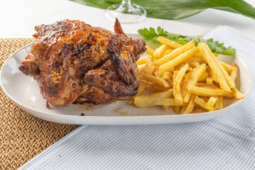 Roast chicken and french fries served on platter