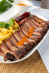 Grilled pork ribs with french fries and sausages