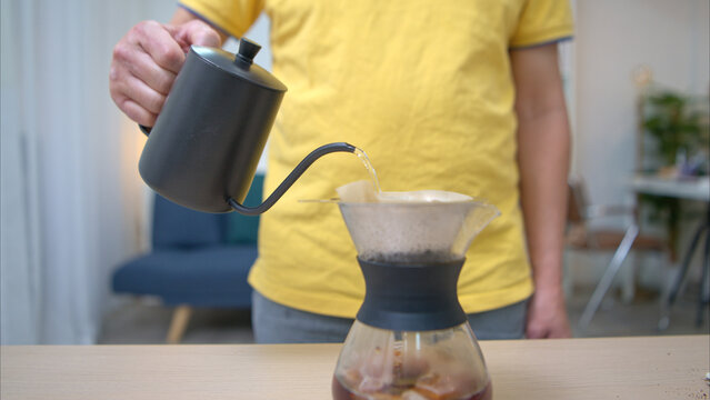 On a holiday, an elderly man relaxes at home and pouring coffee for drink in the morning of the day