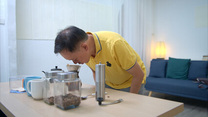 On a holiday, an elderly man relaxes at home and pouring coffee