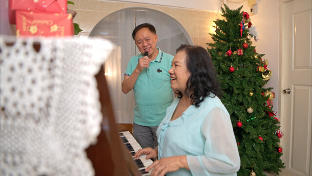 On a holiday, an elderly couple enjoys singing and playing the piano at home