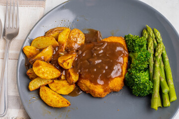chicken breast  with potato wedges top in gravy