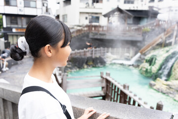 草津温泉旅行で湯畑に来ている10代の女性