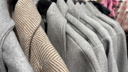 Warm autumn and winter coats on hangers in clothing store. Seasonal outerwear, fashion wardrobe...