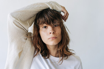 Close-up of a beautiful authentic adolescent girl with brown eyes and brown hair looking at the camera.