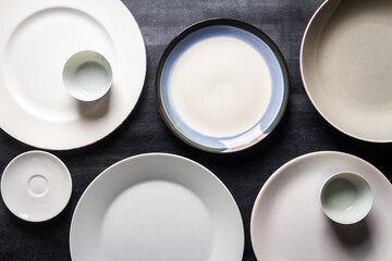 Top view of an empty plates and bowls placed on a black chalkboard background. Flat lay. Top view. Food concept.