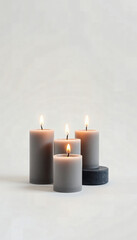 Gray candles with flames on soft background for relaxation atmosphere  