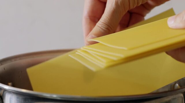 Lasagna pasta sheets placed into boiling water. High quality 4k footage