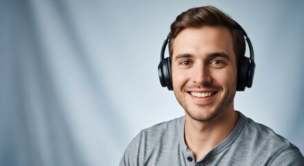 A smiling man wearing headphones against a blue background