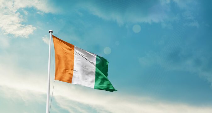 Ivory Coast national flag fluttering. The flag blowing in beautiful soft sky. Ivory Coast national flag for independence day.