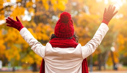Woman in autumn park with arms raised