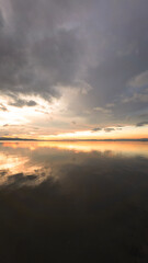 Fototapeta premium Cloudscape Reflection on Calm Water at Sunset