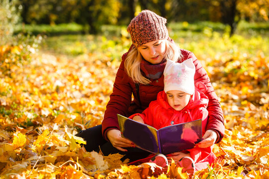 Hello autumn. smiling young mother and daughter in hats outdoors in the city park in autumn having fun time. - Powered by Adobe