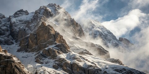 Dramatic snow covered mountain peak with swirling clouds and mist