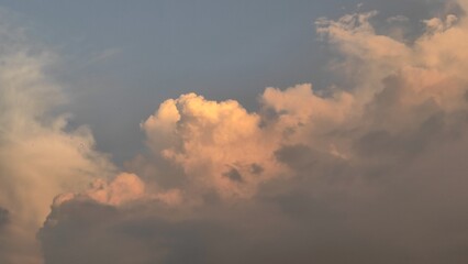 Dramatic smoke from a fire billows into the sky, creating a dark, overcast cloudscape against the sunlight.