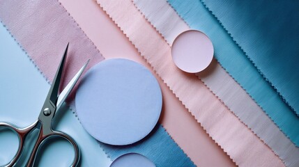 Obraz premium Colorful fabric strips in shades of pink and blue are arranged neatly next to round cutouts. A pair of sharp scissors lies ready for crafting, showcasing a creative workspace
