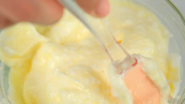 Mixing whipped foamy white eggs with yolk in bowl using spatula cooking omelet on kitchen. Recipe cuisine culinary ingredient. Baking preparing food dish. Prepare super fluffy souffle omelet close-up.