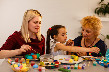 grandmother with granddaughter play with easter eggs, easter time to paint eggs.