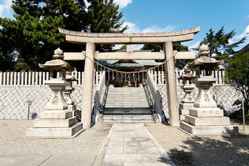 Traditional Stone Torii Gateway and Lanterns Leading to a Japanese Shinto Shrine