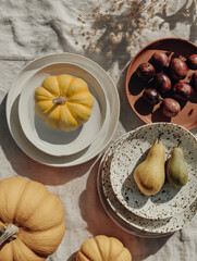 Top view of autumn table setting with yellow pumpkins, plums, and pears. Warm and rustic atmosphere, ideal for seasonal food, cozy lifestyle, and festive decoration concepts.