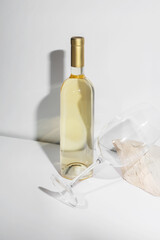 White Wine bottle mockup with golden cap and elegant glass, showcasing a minimalist design on a white background, perfect for branding and marketing concepts