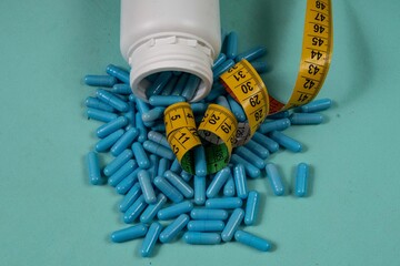 bottle of pills, some of which spilled onto a light blue surface