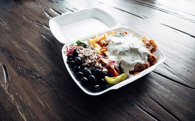Doner kebab plate in plastic container on a table, Turkish takeaway fast food meal