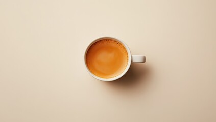 Overhead view of a cream-colored coffee cup filled with light brown espresso