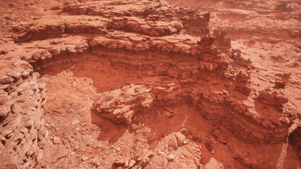 A vast, barren expanse showcases reddish rock formations under a dusty atmosphere, resembling a distant planet.
