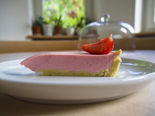 Clean slice of a home baked strawberry cake in an elegant setting. 
