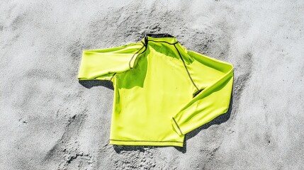 rashguard. Neon surf rashguard laid flat on wet sand, material stretched. lifestyle magazines, social media lookbooks, designed for lifestyle magazines and social media content.