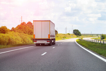 A modern semi-trailer truck transports cargo along a highway on a sunny day. Concept of payment for cargo transportation, price for freight. Copy space for text, industry